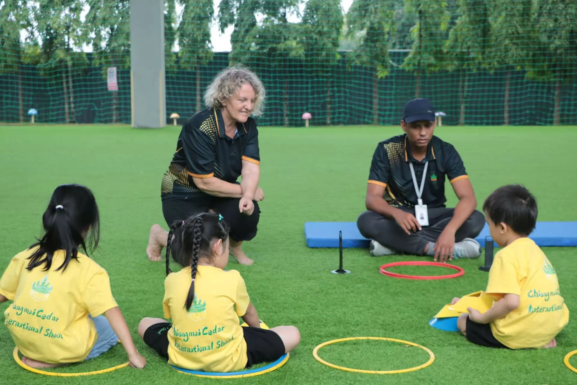Teachers and children during an outdoor PE session